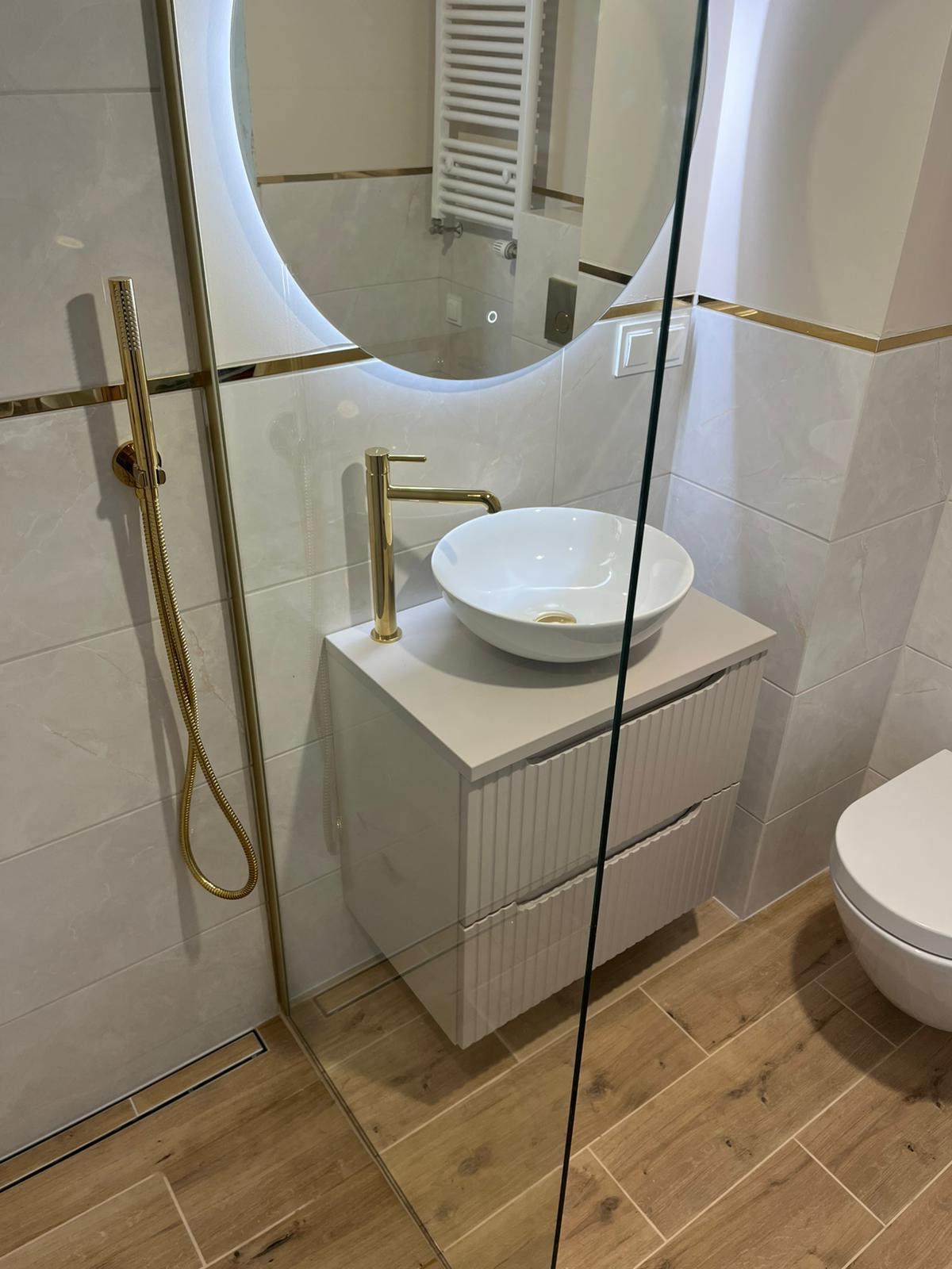 Wet room with gold fixtures and vessel sink